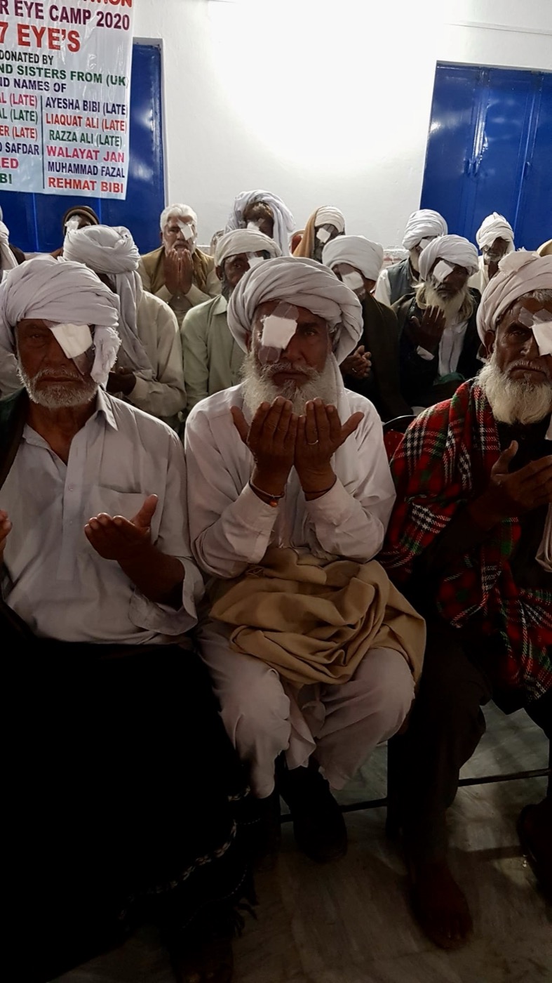 Elderly men with eye patches giving thanks in prayer after free cataract surgery