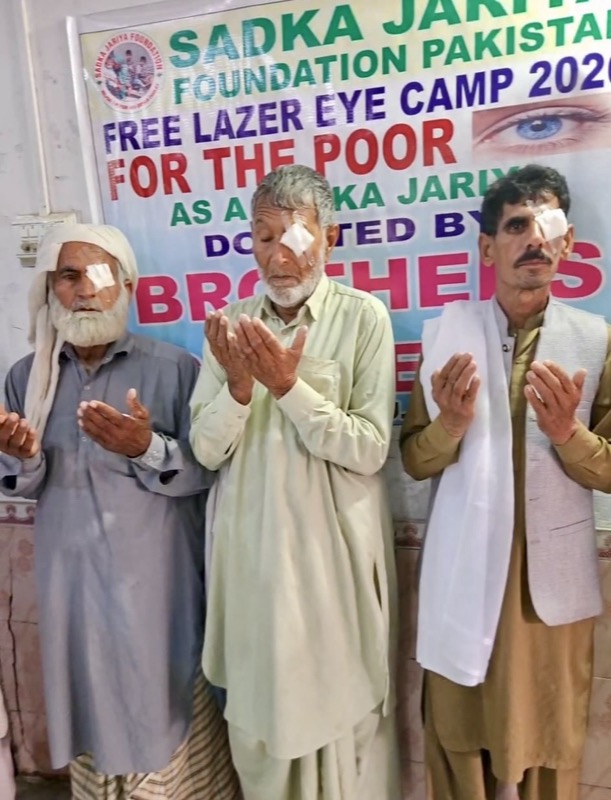 Men raising their hands in prayer after a free eye camp