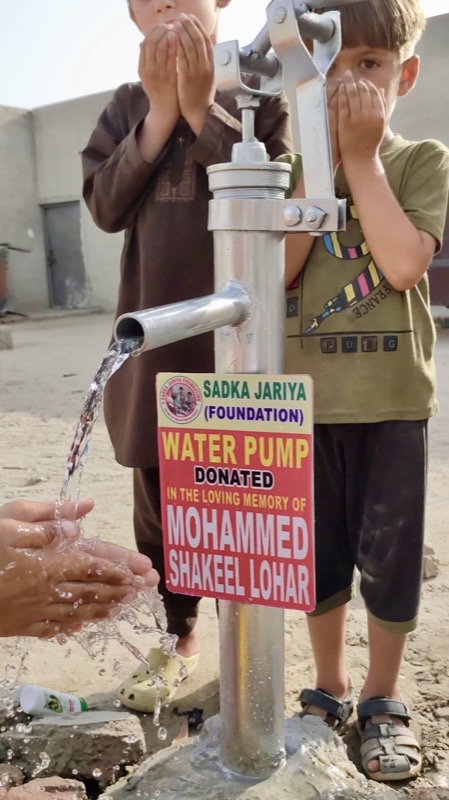 Children drinking clean water from a newly fitted hand pump